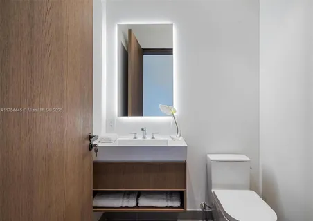 a bathroom with a sink toilet and mirror