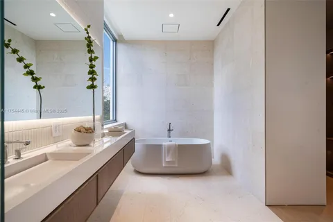 a spacious bathroom with a double vanity sink toilet mirror and bathtub