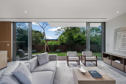 a living room with furniture and a floor to ceiling window