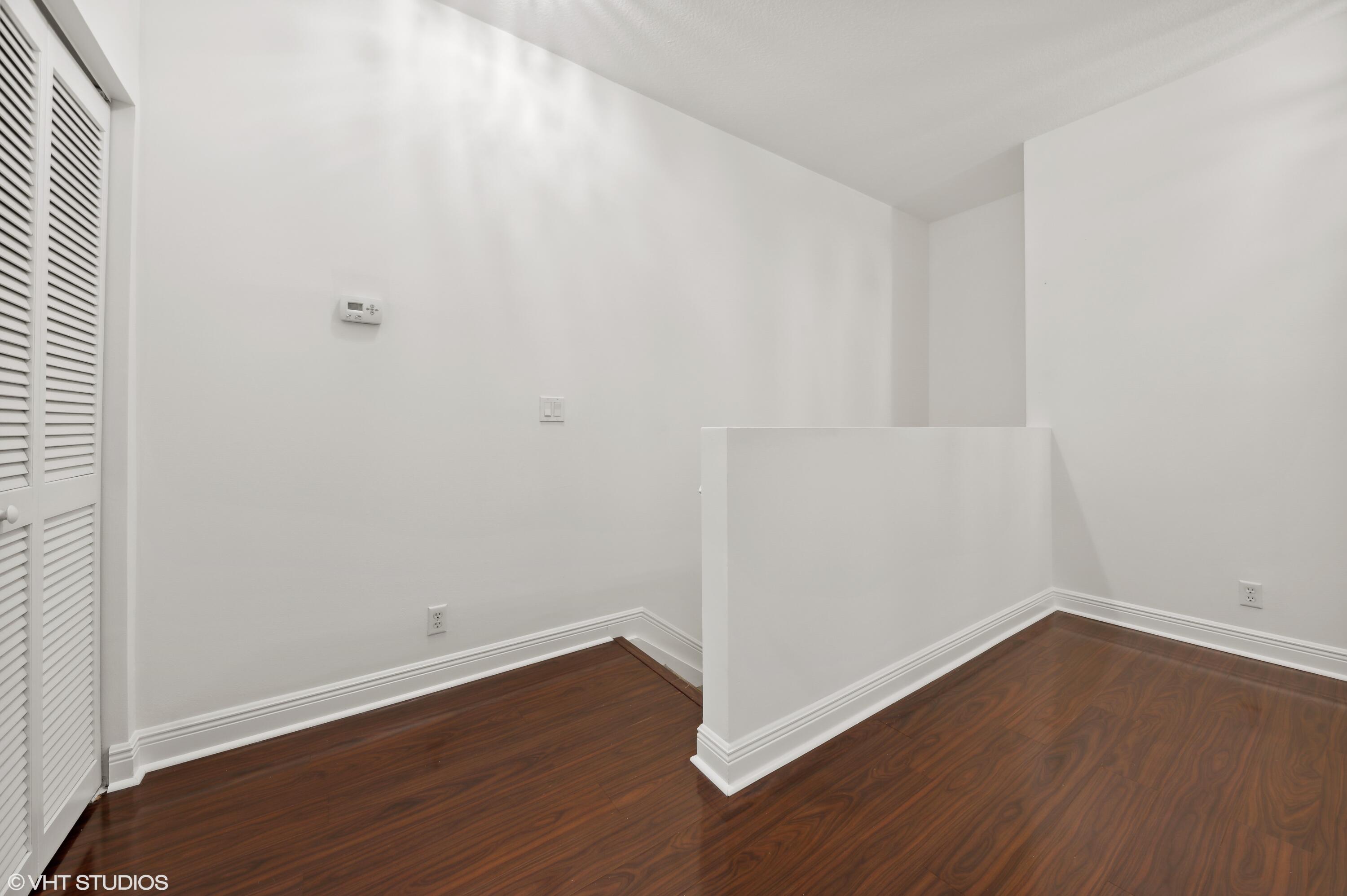 103 Lighthouse Circle, Unit D Tequesta, FL 33469 - Photo 19 of 36 an empty room with wooden floor