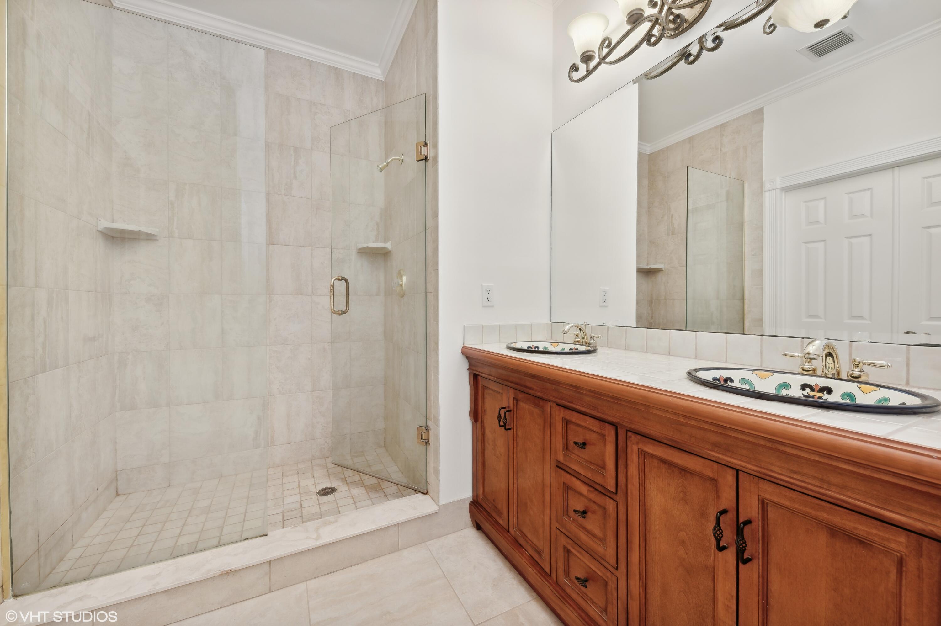 103 Lighthouse Circle, Unit D Tequesta, FL 33469 - Photo 23 of 36 a spacious bathroom with double sink and a mirror