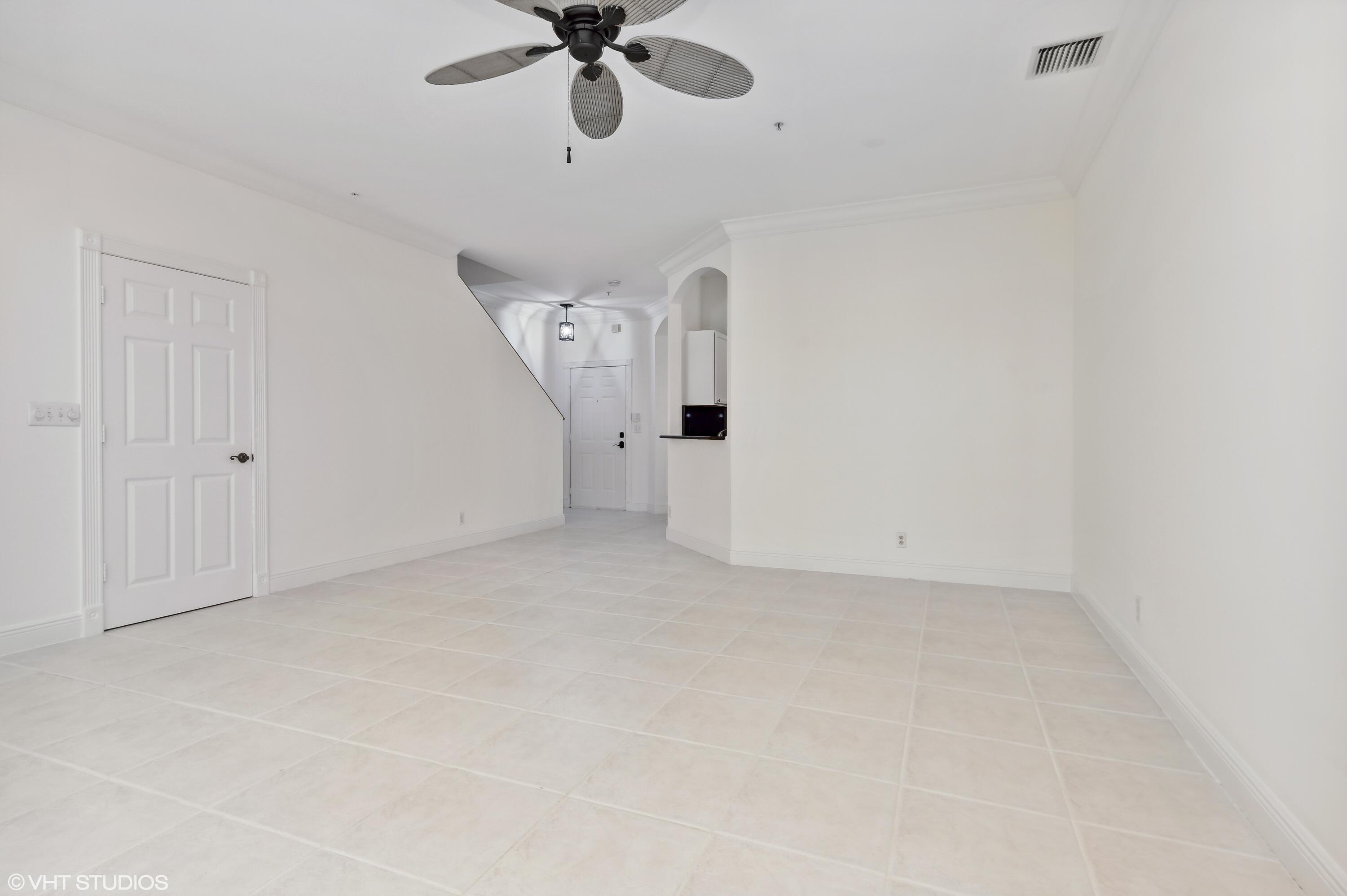 103 Lighthouse Circle, Unit D Tequesta, FL 33469 - Photo 4 of 36 an empty room with a ceiling fan and a window