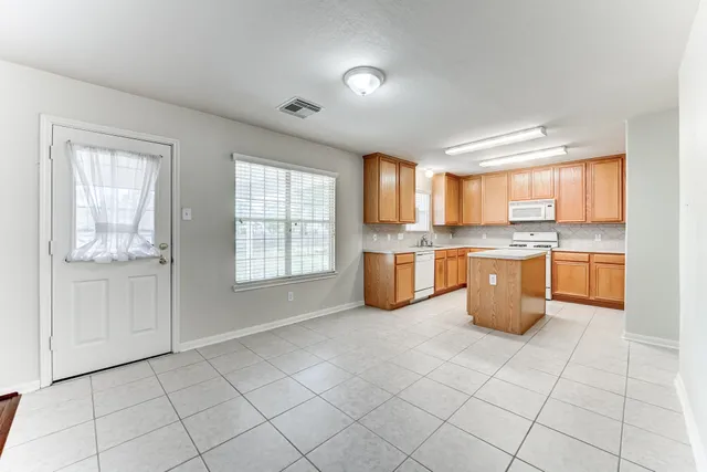 a kitchen with stainless steel appliances a sink window and cabinets