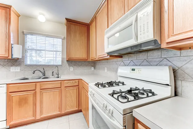 a kitchen with a sink stove top oven and cabinets