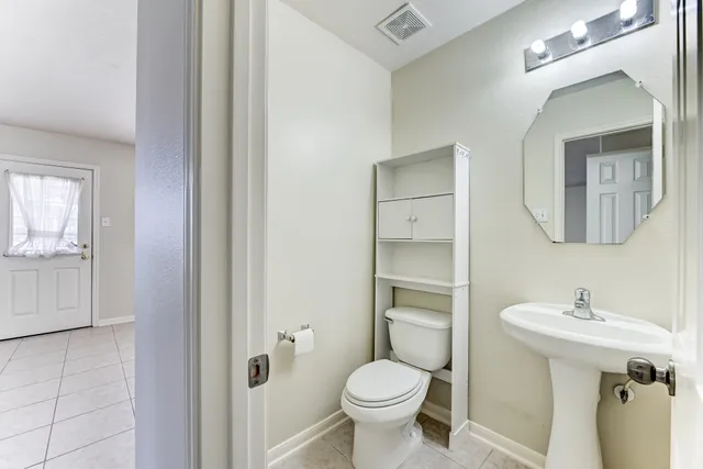 a bathroom with a toilet sink and mirror