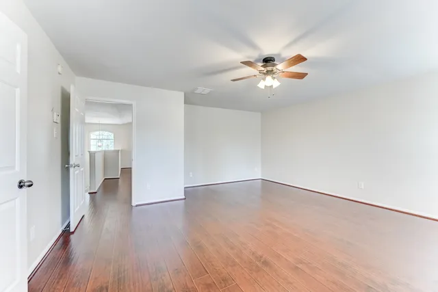 a view of an empty room with wooden floor
