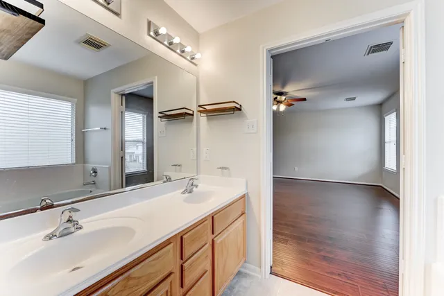 a bathroom with a double vanity sink a mirror and shower
