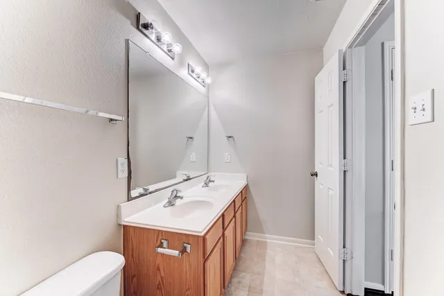a bathroom with a sink a toilet and mirror