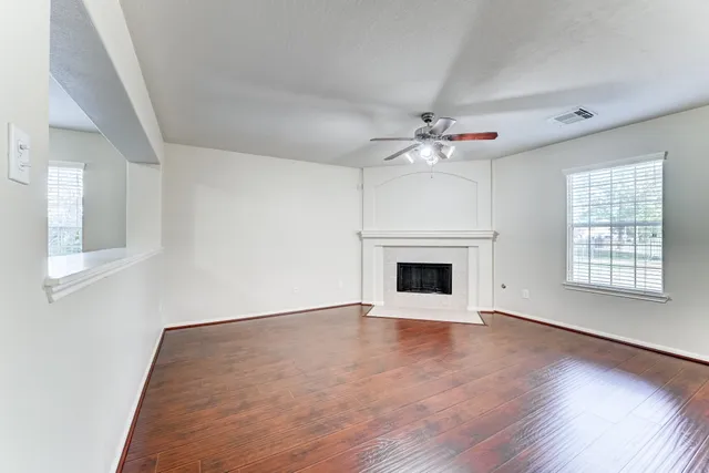a view of an empty room with a fireplace and a window