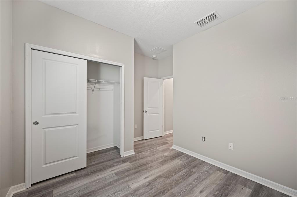 4303 Moon Shadow Loop Mulberry, FL 33860 - Photo 18 of 30 a view of an empty room with closet and wooden floor