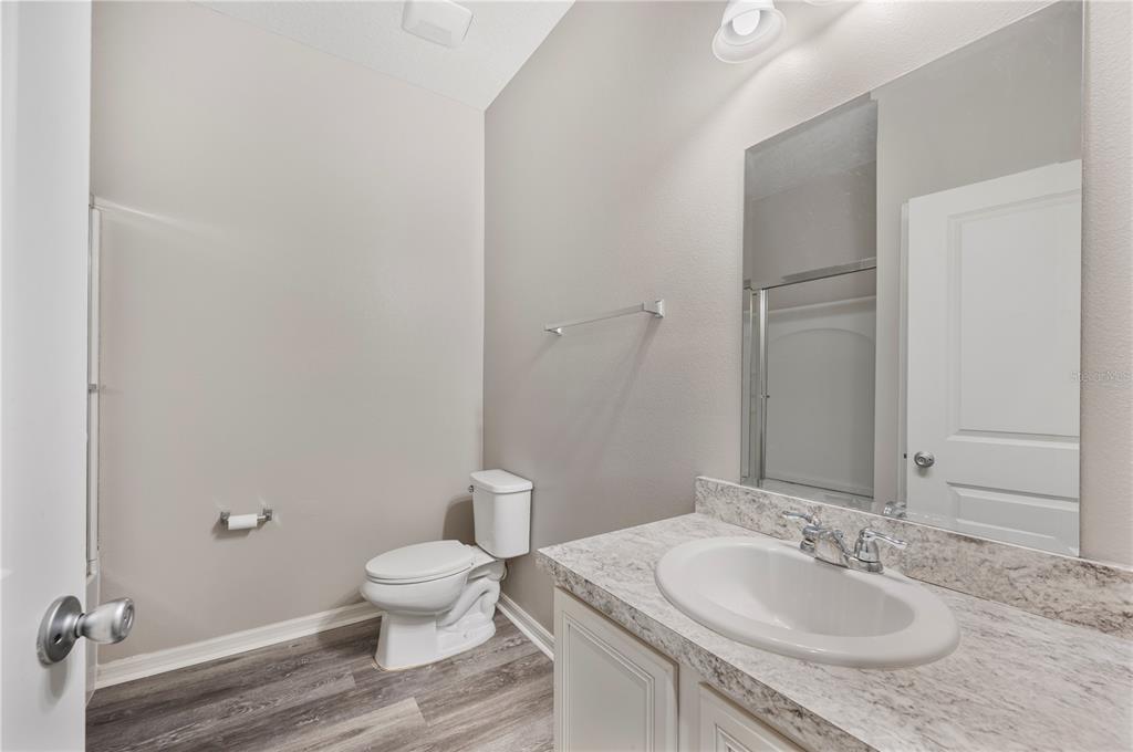 4303 Moon Shadow Loop Mulberry, FL 33860 - Photo 20 of 30 a bathroom with a granite countertop sink a toilet and a mirror