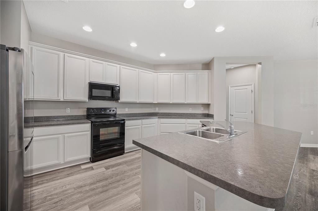 4303 Moon Shadow Loop Mulberry, FL 33860 - Photo 2 of 30 a kitchen with sink a microwave and cabinets