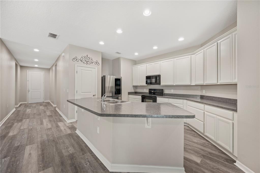 4303 Moon Shadow Loop Mulberry, FL 33860 - Photo 3 of 30 a kitchen with stainless steel appliances granite countertop a sink a stove and cabinets