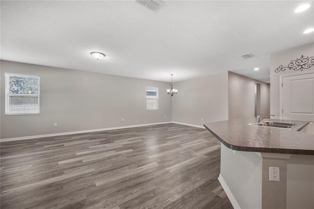 4303 Moon Shadow Loop Mulberry, FL 33860 - Photo 5 of 30 an empty room with kitchen appliances and wooden floor