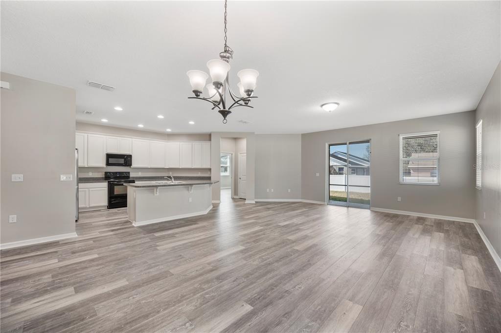 4303 Moon Shadow Loop Mulberry, FL 33860 - Photo 6 of 30 a view of a kitchen with kitchen island stainless steel appliances sink and wooden floor