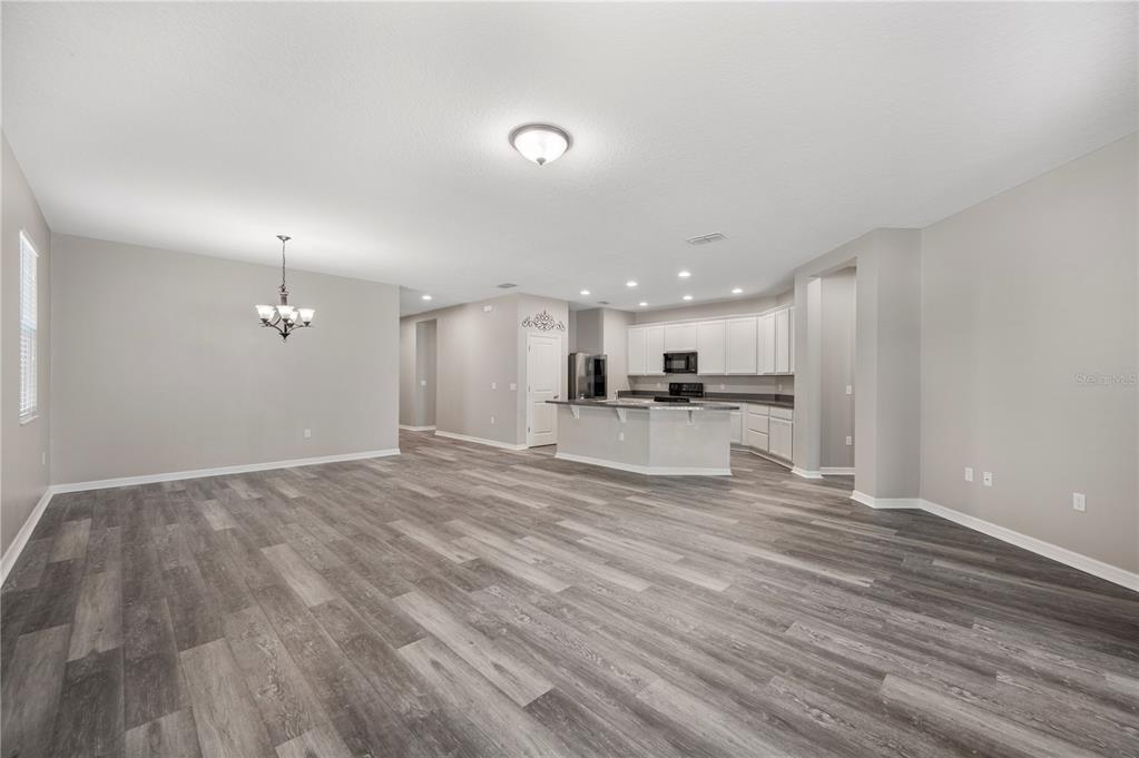 4303 Moon Shadow Loop Mulberry, FL 33860 - Photo 8 of 30 a view of kitchen and empty room with wooden floor