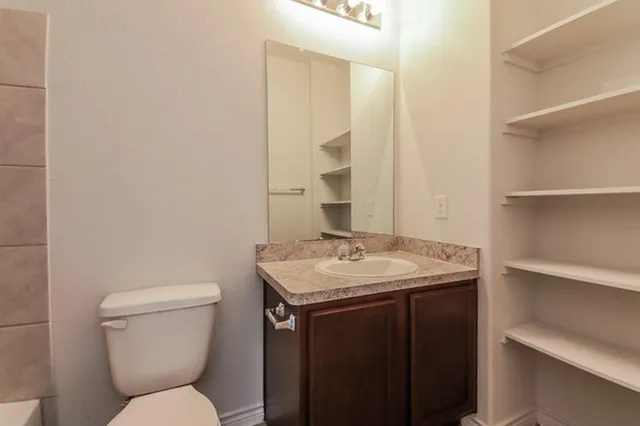 a bathroom with a toilet sink and mirror