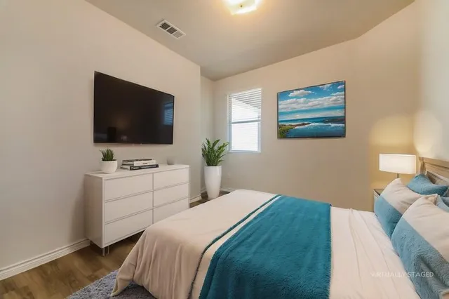 a bedroom with a bed and a flat screen tv