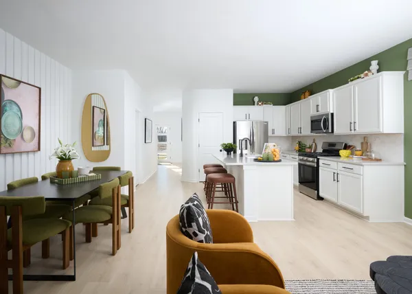 a kitchen with stainless steel appliances granite countertop a stove a sink a dining table and chairs