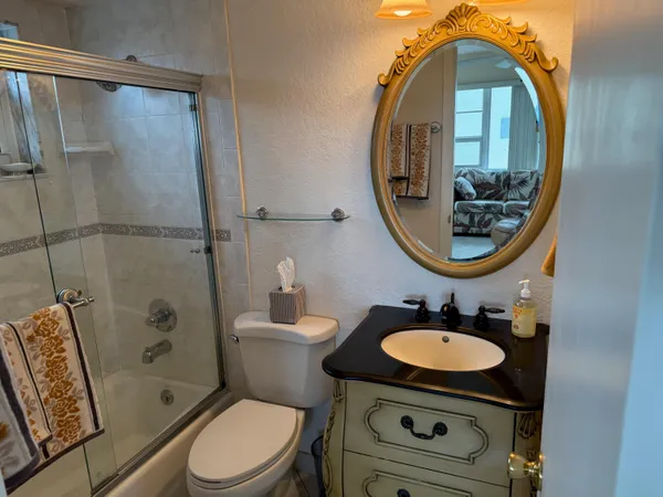 a bathroom with a sink toilet a mirror and shower