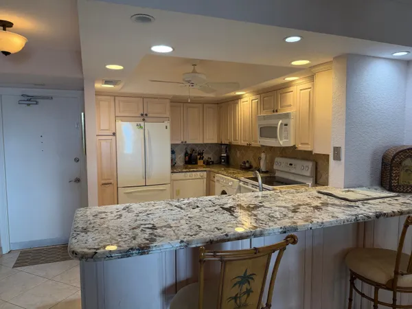a kitchen with kitchen island a sink stove and refrigerator