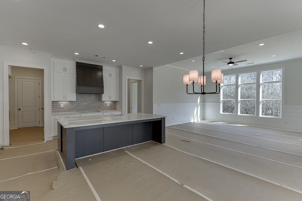 5470 Settingdown Road Cumming, GA 30028 - Photo 11 of 46 a view with kitchen island a sink wooden floor and a large window