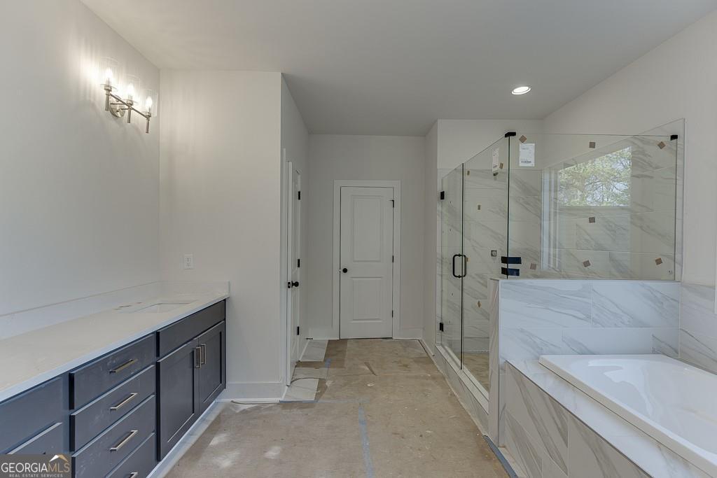 5470 Settingdown Road Cumming, GA 30028 - Photo 40 of 46 a spacious bathroom with a granite countertop sink a toilet a shower and a mirror