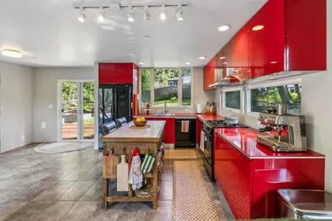 a kitchen with a stove and a view of living room