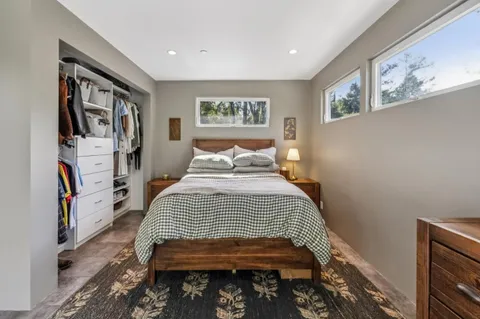 a spacious bedroom with a bed and large windows