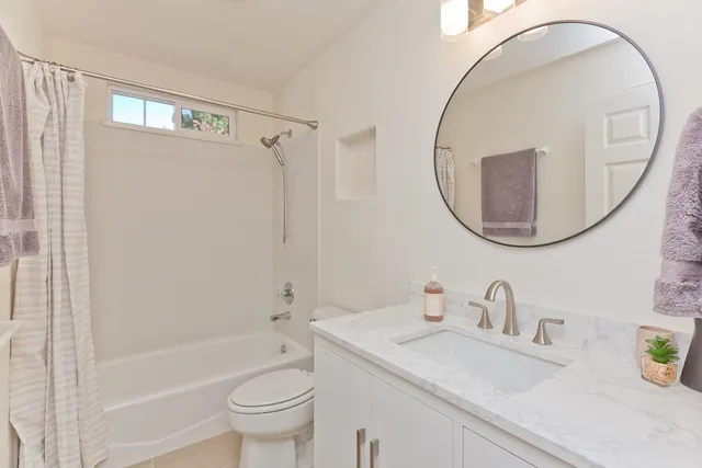 a bathroom with a sink a toilet and a mirror