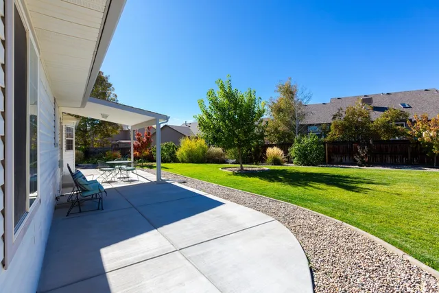 a view of a patio with couches table and chairs under an umbrella