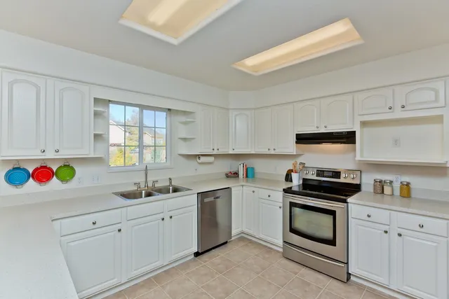 a kitchen with white cabinets sink and white appliances