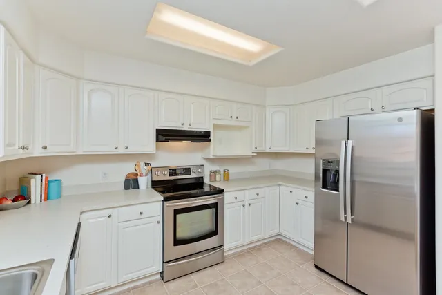 a kitchen with cabinets stainless steel appliances and a counter space