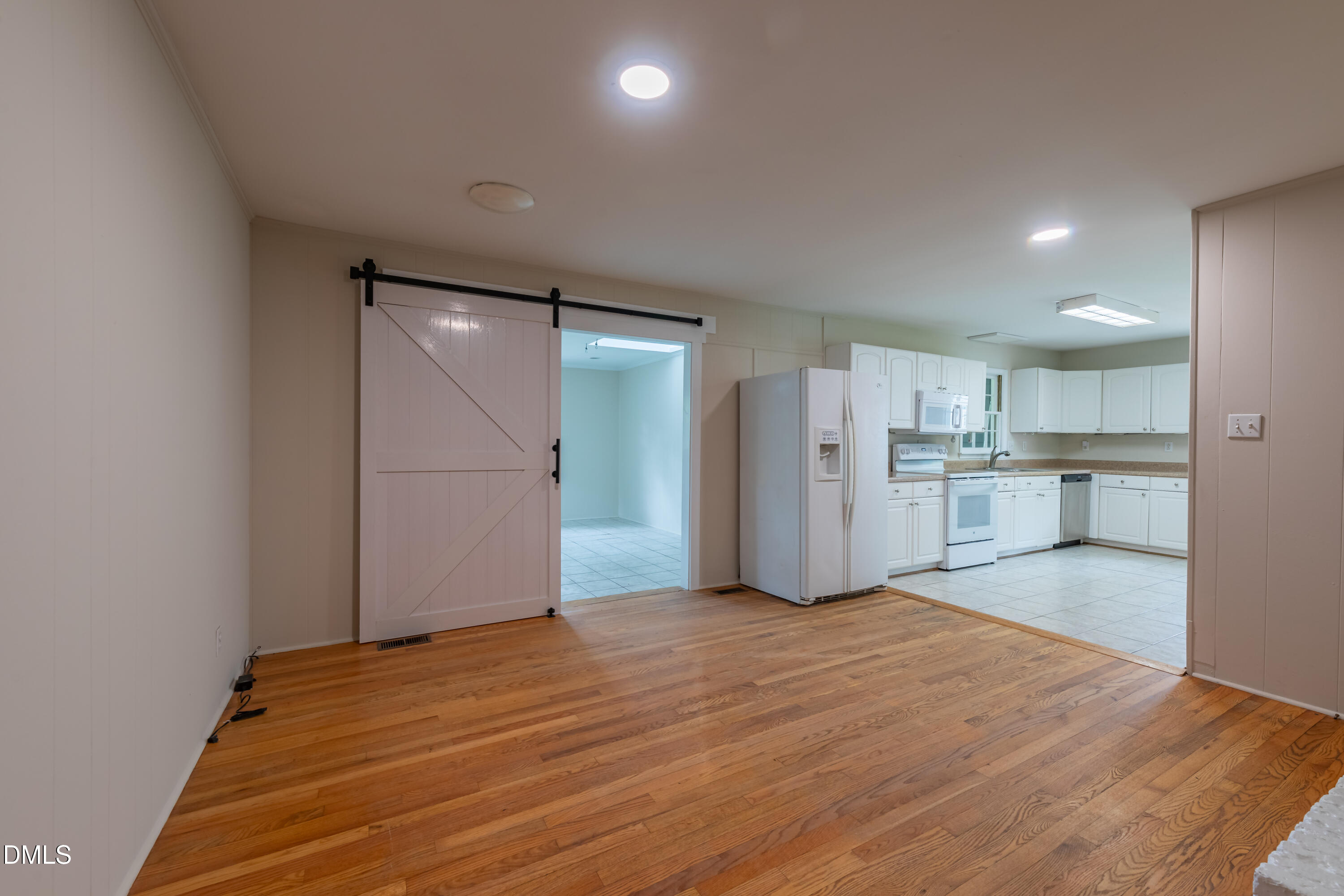 408 Ortega Road Raleigh, NC 27609 - Photo 8 of 25 a view of an empty room with wooden floor and a kitchen