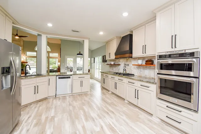 a kitchen with stainless steel appliances granite countertop a refrigerator and a sink
