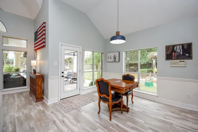 a kitchen with stainless steel appliances granite countertop a stove top oven a sink dishwasher a dining table and chairs with wooden floor