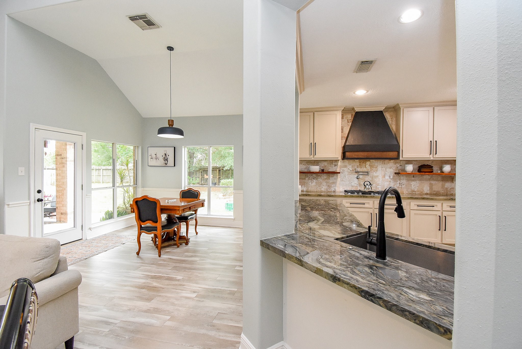 30518 Aldine Westfield Road Spring, TX 77386 - Photo 15 of 50 a kitchen with stainless steel appliances granite countertop a stove top oven a sink dishwasher a dining table and chairs with wooden floor