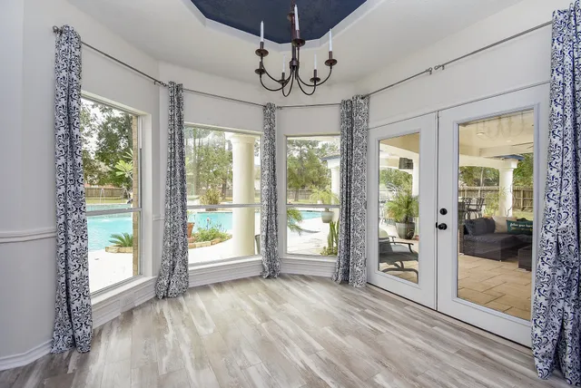 a bathroom with a granite countertop sink a mirror a window and a shower