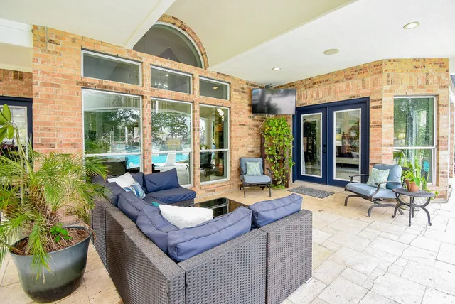 a living room with patio furniture and a potted plant