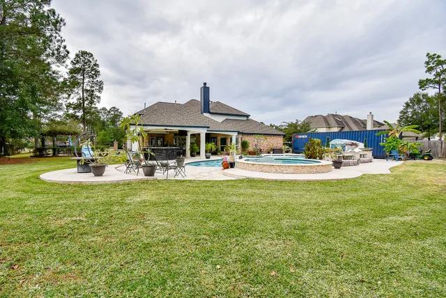 a view of a patio with table and chairs potted plants and large tree