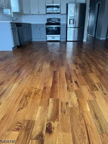 a view of a kitchen with wooden floor and electronic appliances