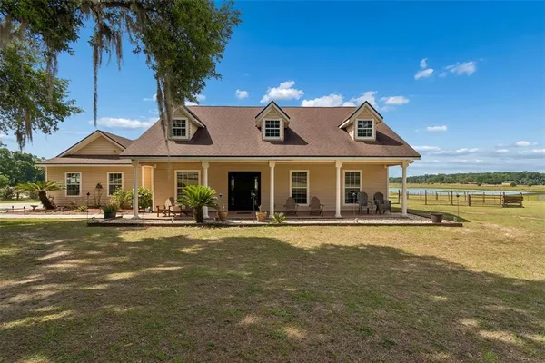 a front view of a house with swimming pool and a yard