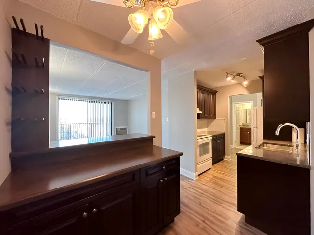 a kitchen with granite countertop a sink cabinets and wooden floor