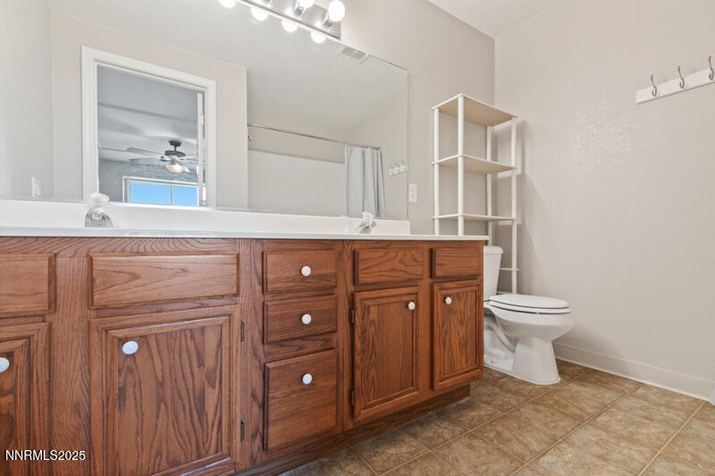 5005 Azurite Drive Reno, NV 89508 - Photo 15 of 33 a bathroom with a toilet a sink and mirror