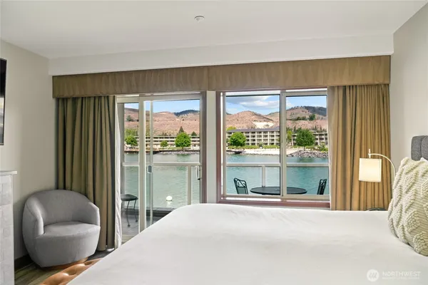 a bedroom with a bed and glass window