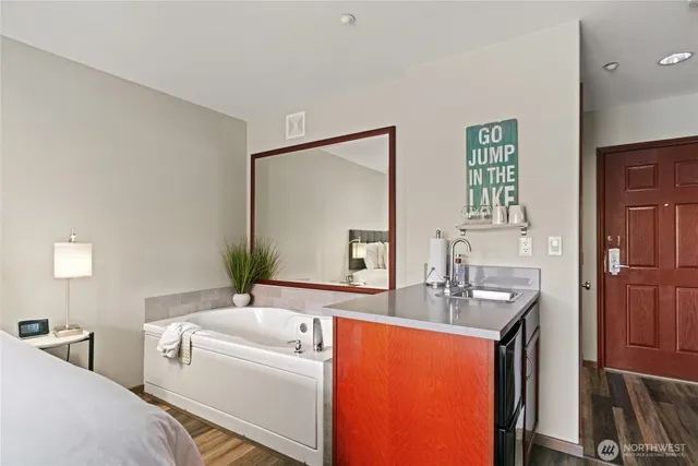 a en suite bathroom with sink a mirror and a bathtub