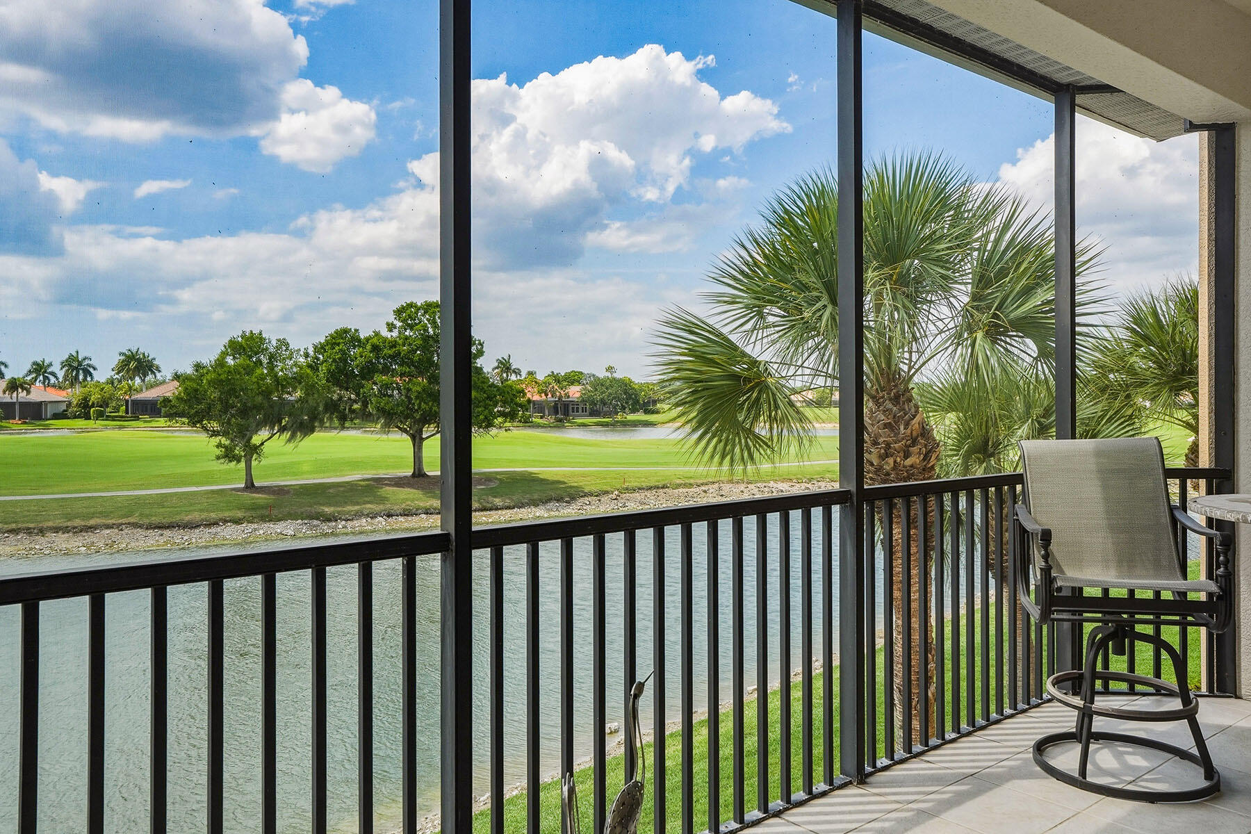 8605 Champions Point, Unit 103 Naples, FL 34113 - Photo 21 of 44 a view of a balcony with floor to ceiling windows and wooden fence