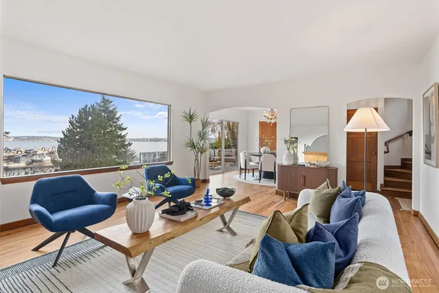 a living room with furniture a fireplace and a large window