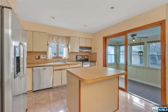 a kitchen with stainless steel appliances granite countertop a refrigerator and a stove top oven