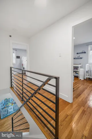 a view of a hallway with wooden floor and staircase